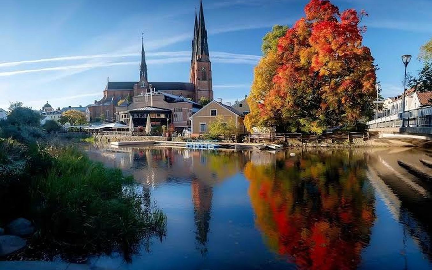 Uppsala domkyrka speglad i Fyrisån med höstfärger